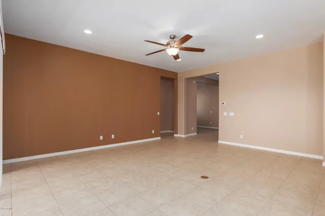 a view of an empty room with a ceiling fan