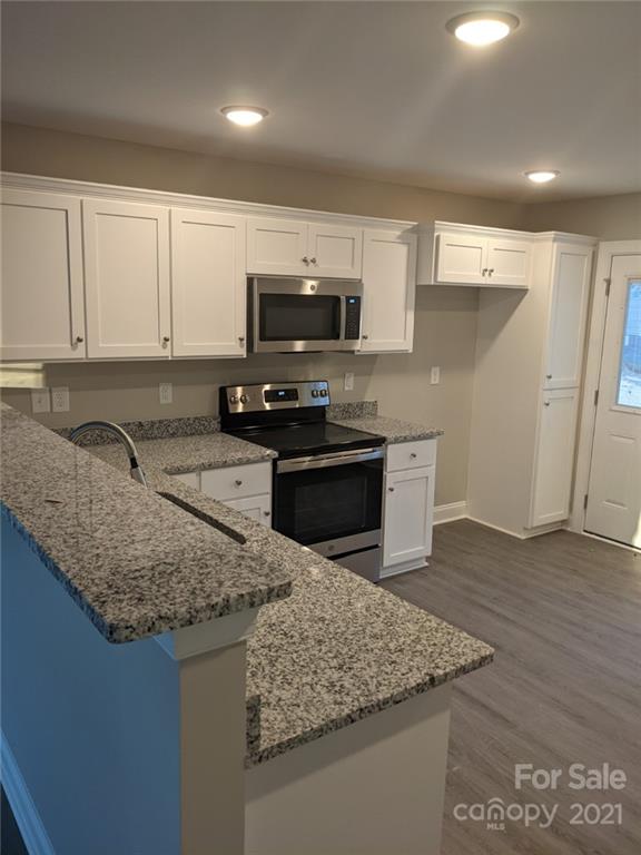 409 South Ridge Avenue Kannapolis, NC 28083 - Photo 4 of 13 a kitchen with stainless steel appliances granite countertop a sink stove and microwave