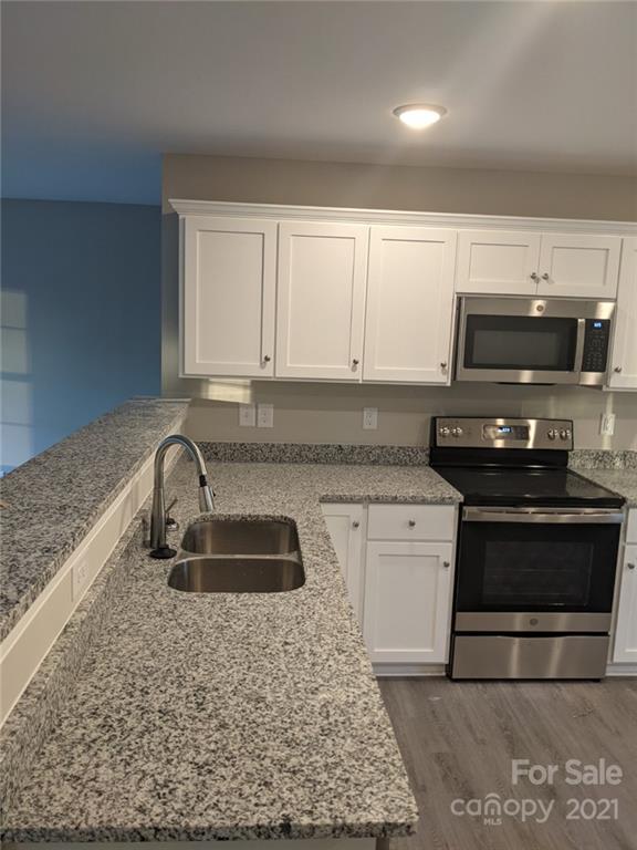 409 South Ridge Avenue Kannapolis, NC 28083 - Photo 8 of 13 a kitchen with granite countertop a stove and a sink