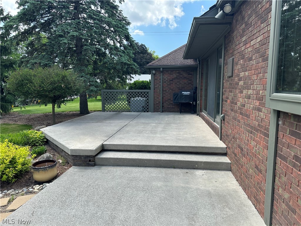 3985 Wiers Road Willard, OH 44890 - Photo 8 of 50 Expansive concrete patio featuring a two-tier design and a brick facade