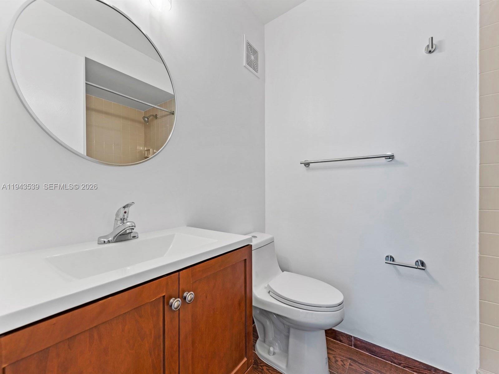 4560 Southwest 68th Ct Circle, Unit 619 Miami, FL 33155 - Photo 13 of 23 a bathroom with a sink a mirror and toilet