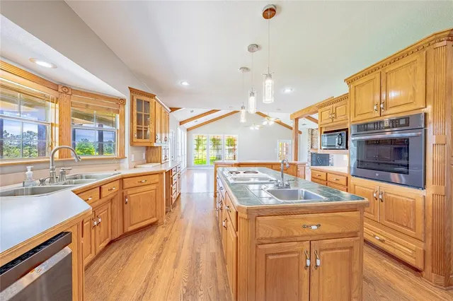 a kitchen with stainless steel appliances granite countertop a sink and a stove