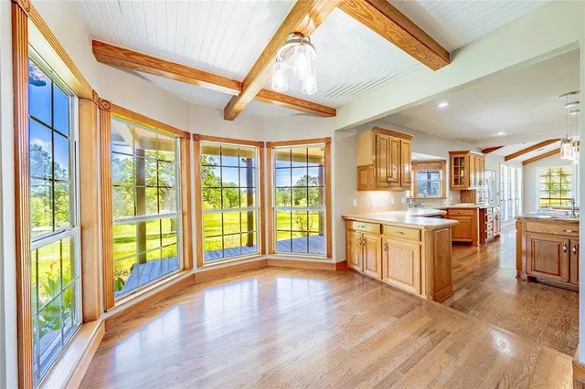 a large kitchen with granite countertop a large window a sink and stainless steel appliances