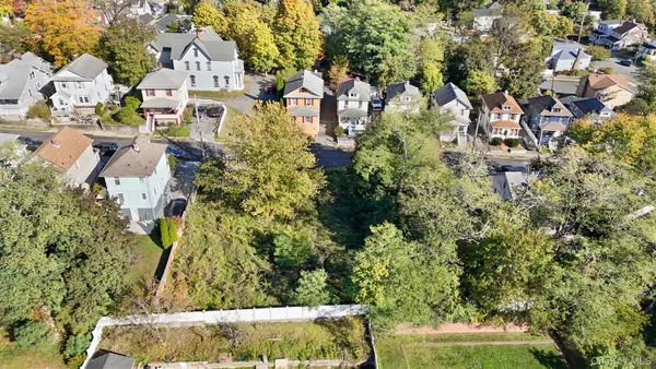 an aerial view of residential house with outdoor space and trees all around