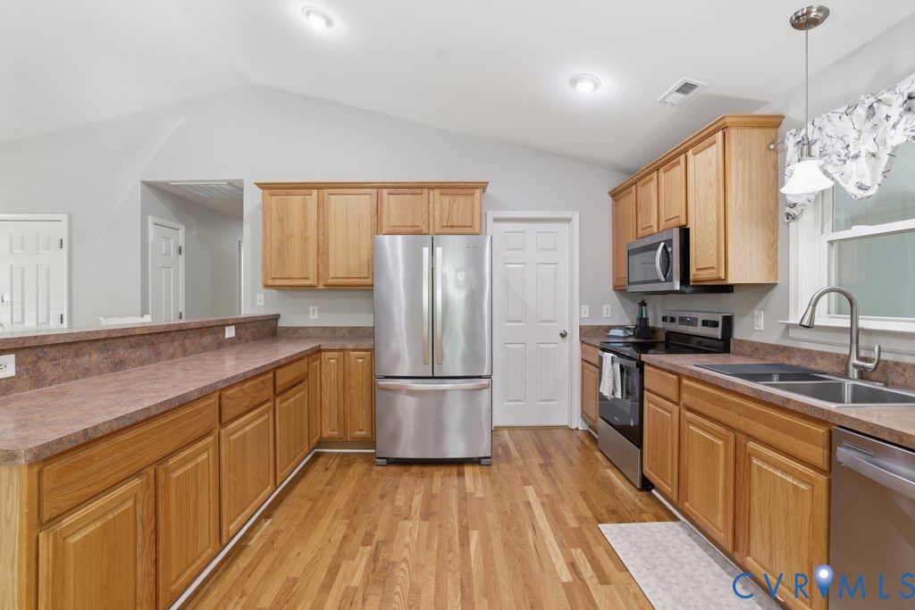 5307 St Pauls Church Road Goochland, VA 23063 - Photo 14 of 44 a kitchen with stainless steel appliances granite countertop a refrigerator a sink dishwasher a stove with wooden cabinets and floor