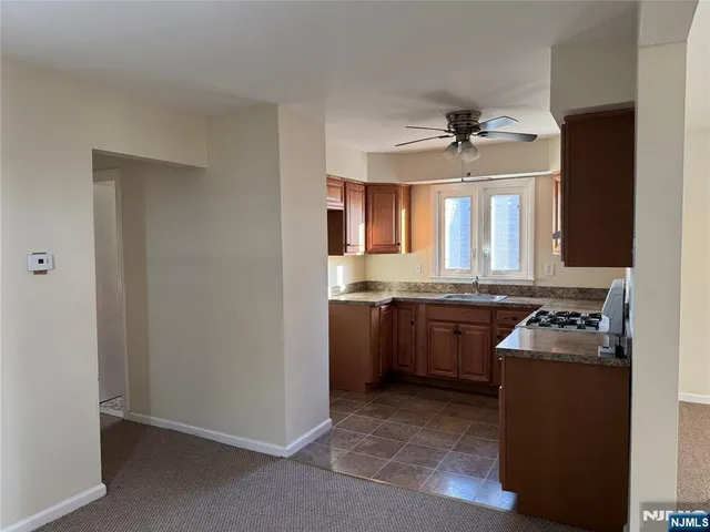a kitchen with granite countertop a sink stainless steel appliances and cabinets
