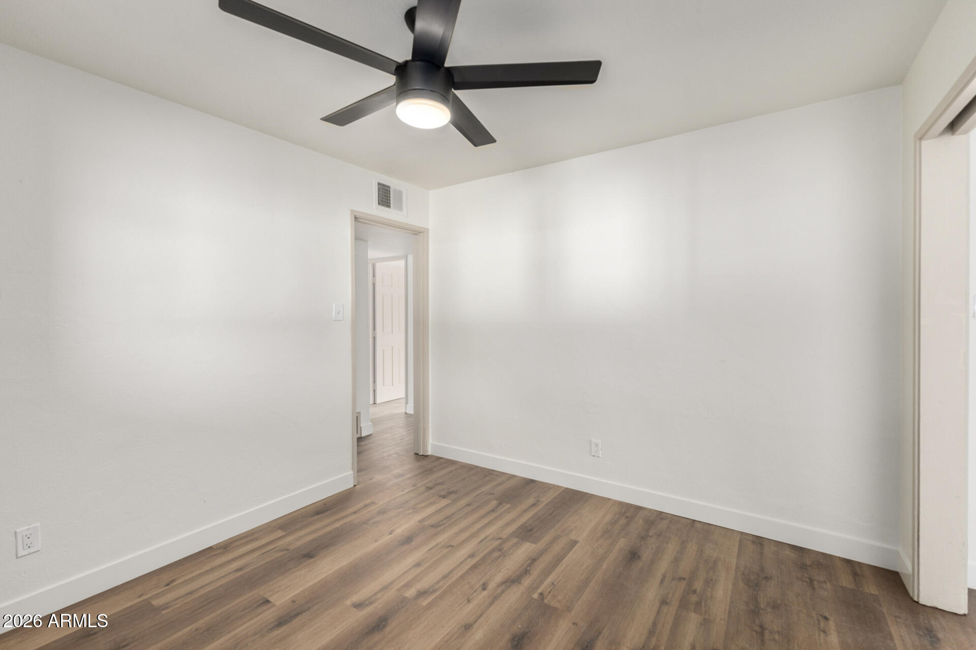 2114 West Rancho Drive Phoenix, AZ 85015 - Photo 13 of 29 an empty room with wooden floor and ceiling fan