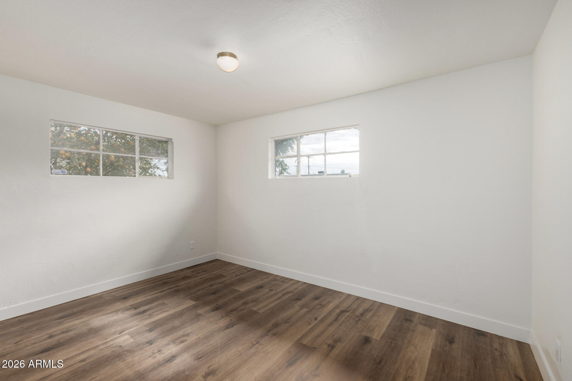 2114 West Rancho Drive Phoenix, AZ 85015 - Photo 17 of 29 an empty room with wooden floor and windows