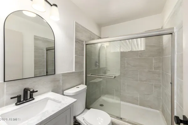 a bathroom with a sink a toilet and shower