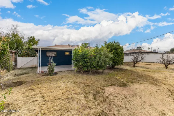 a view of a house with backyard and sitting area