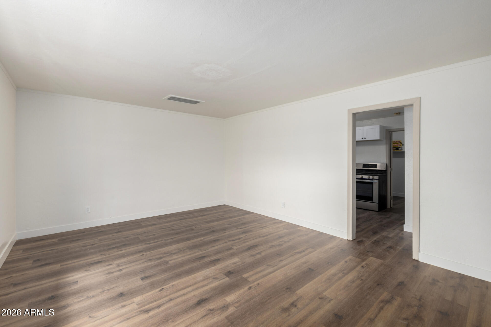 2114 West Rancho Drive Phoenix, AZ 85015 - Photo 7 of 29 a view of an empty room with wooden floor