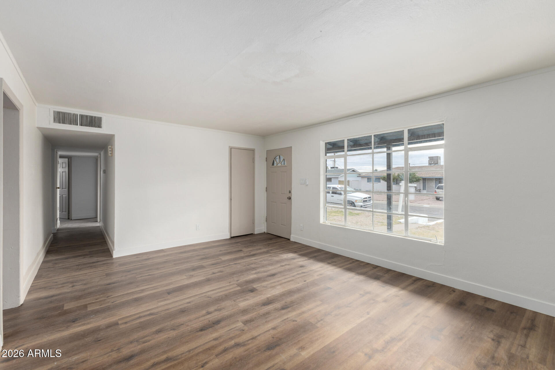 2114 West Rancho Drive Phoenix, AZ 85015 - Photo 8 of 29 a view of an empty room with wooden floor and a window