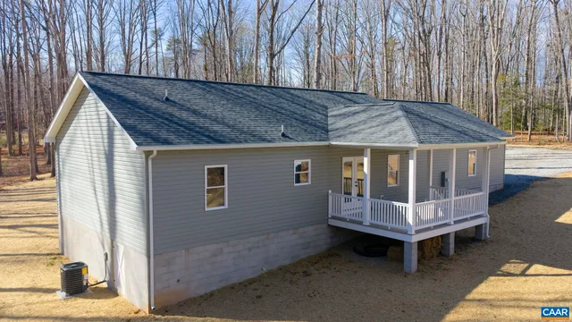 a view of a backyard with a small deck and wooden fence