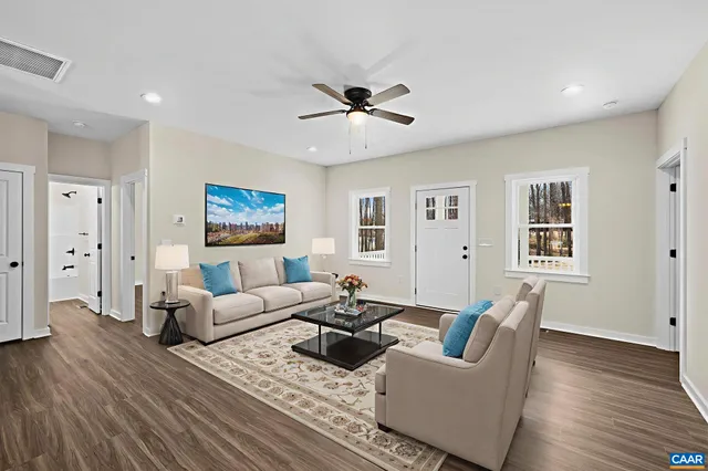 a living room with furniture and wooden floor