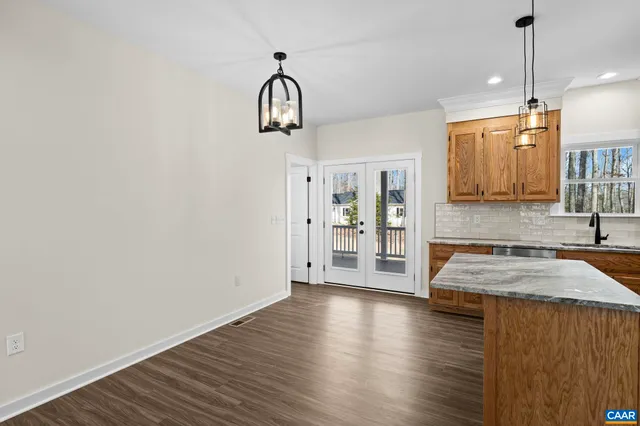 a kitchen with stainless steel appliances granite countertop a stove a sink and a wooden floor