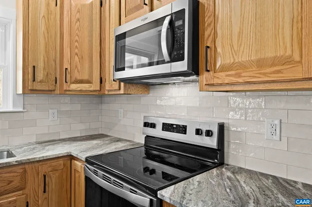 a kitchen with wooden cabinets and a stove top oven