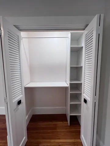 a view of walk in closet with empty racks