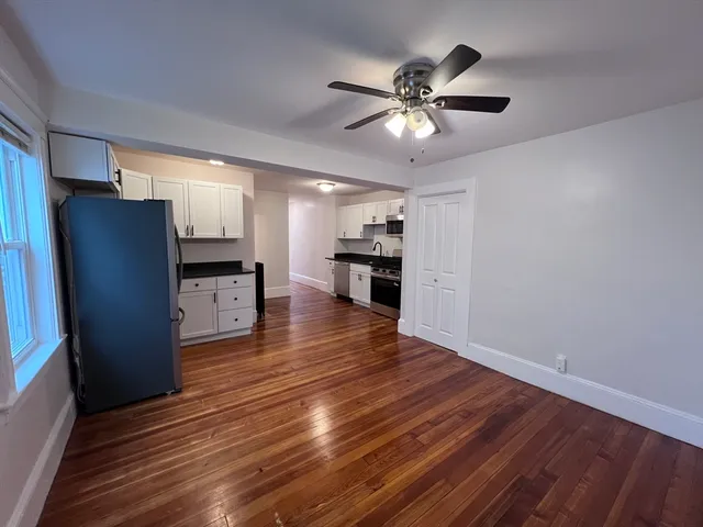 a view of kitchen with refrigerator stove and wooden floor
