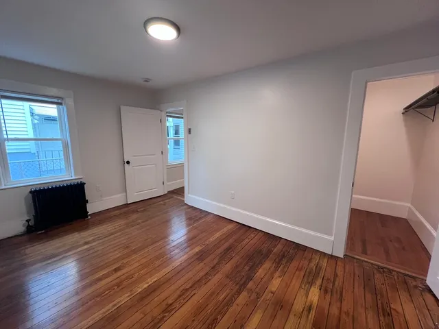 an empty room with wooden floor and window