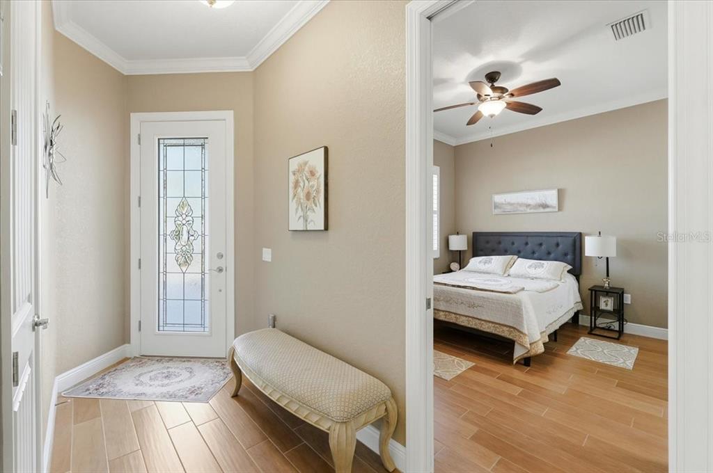 708 Teaberry Trail Polk City, FL 33868 - Photo 12 of 46 a bedroom with a bed and a chandelier