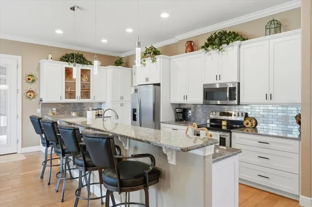 a kitchen with stainless steel appliances kitchen island granite countertop a sink and cabinets