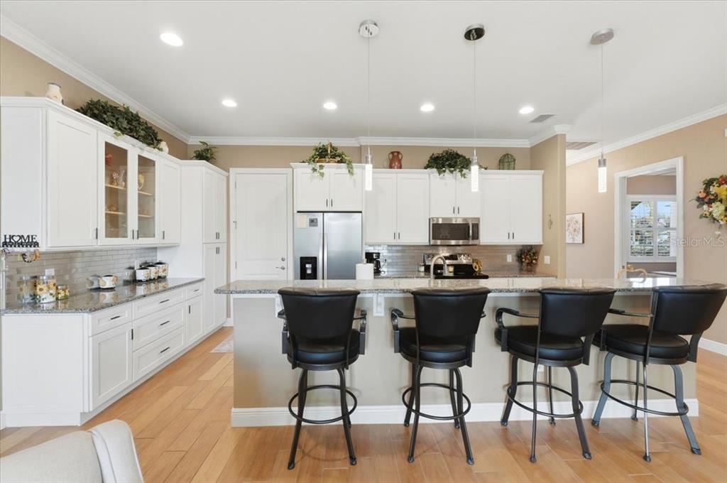 708 Teaberry Trail Polk City, FL 33868 - Photo 18 of 46 a kitchen with stainless steel appliances kitchen island granite countertop a sink and cabinets