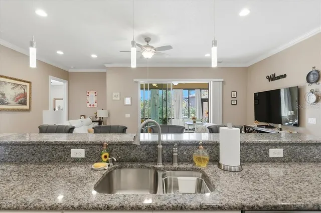a kitchen with stainless steel appliances kitchen island granite countertop a refrigerator and a sink