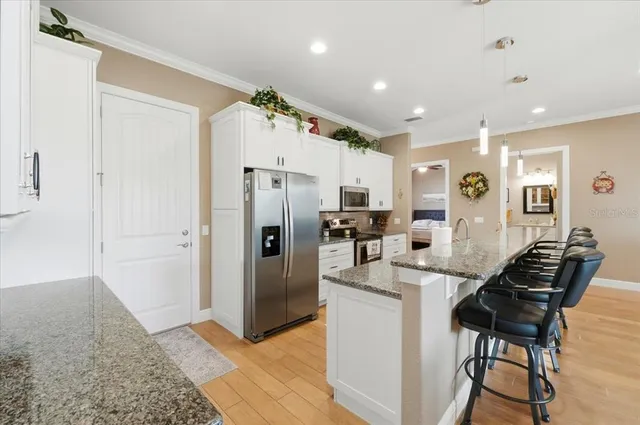 a large kitchen with stainless steel appliances granite countertop a lot of counter space and a stove