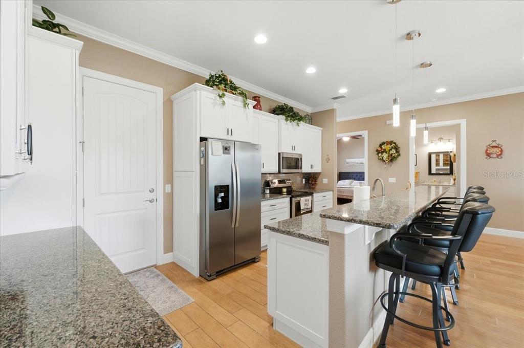 708 Teaberry Trail Polk City, FL 33868 - Photo 21 of 46 a kitchen with stainless steel appliances kitchen island granite countertop a refrigerator and a sink