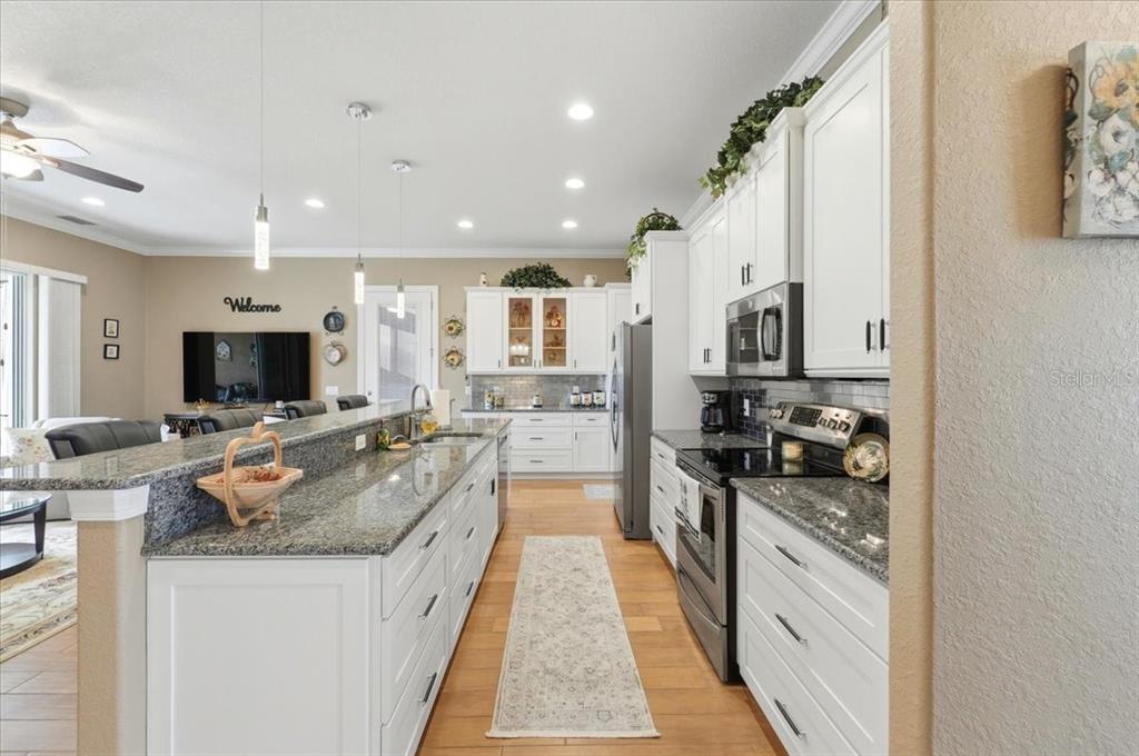 708 Teaberry Trail Polk City, FL 33868 - Photo 22 of 46 a large kitchen with stainless steel appliances granite countertop a lot of counter space and a stove