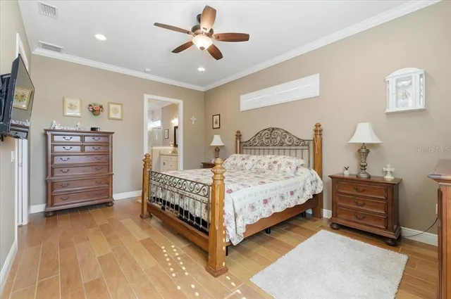 a bedroom with a bed and a flat tv screen on dresser
