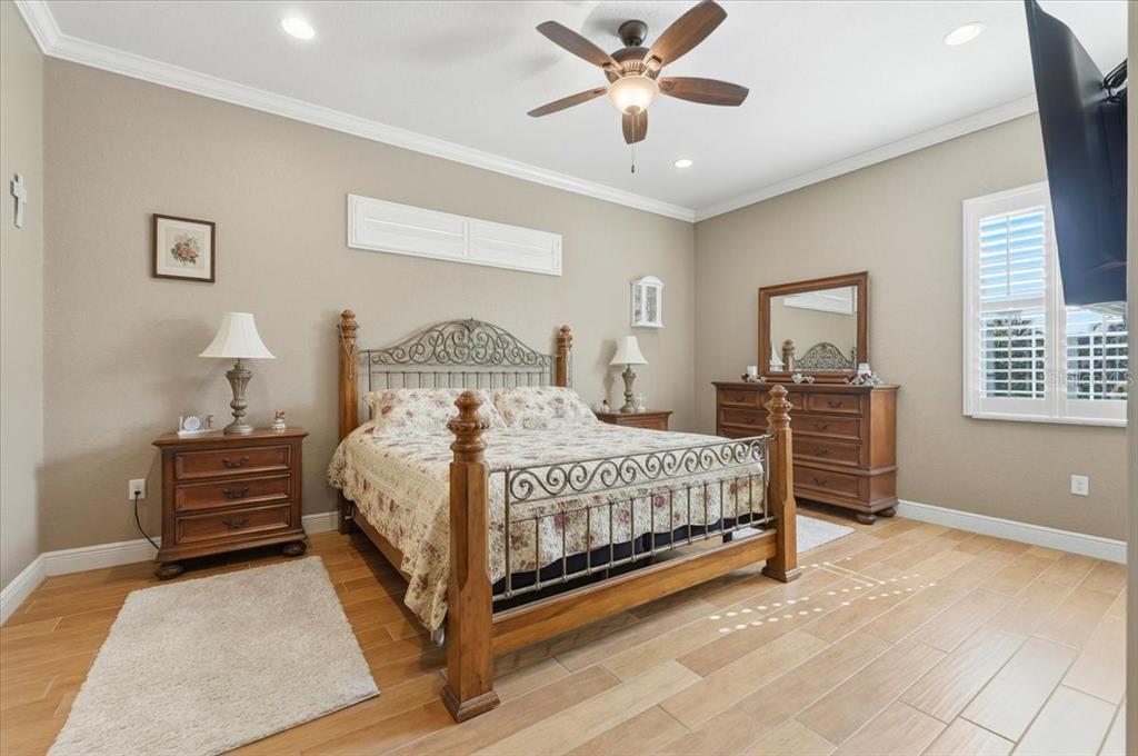 708 Teaberry Trail Polk City, FL 33868 - Photo 28 of 46 a bedroom with a bed chandelier and a window