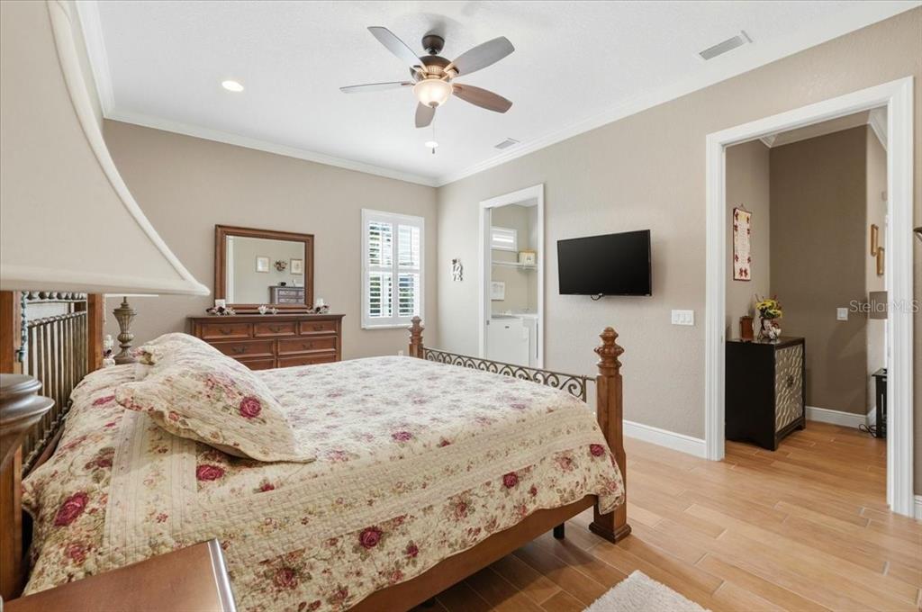 708 Teaberry Trail Polk City, FL 33868 - Photo 29 of 46 a bed room with a bed a television and a large mirror