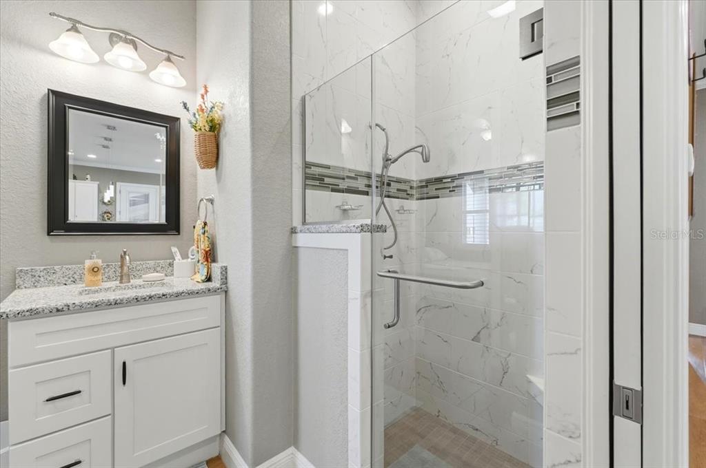 708 Teaberry Trail Polk City, FL 33868 - Photo 40 of 46 a bathroom with a granite countertop sink mirror and vanity