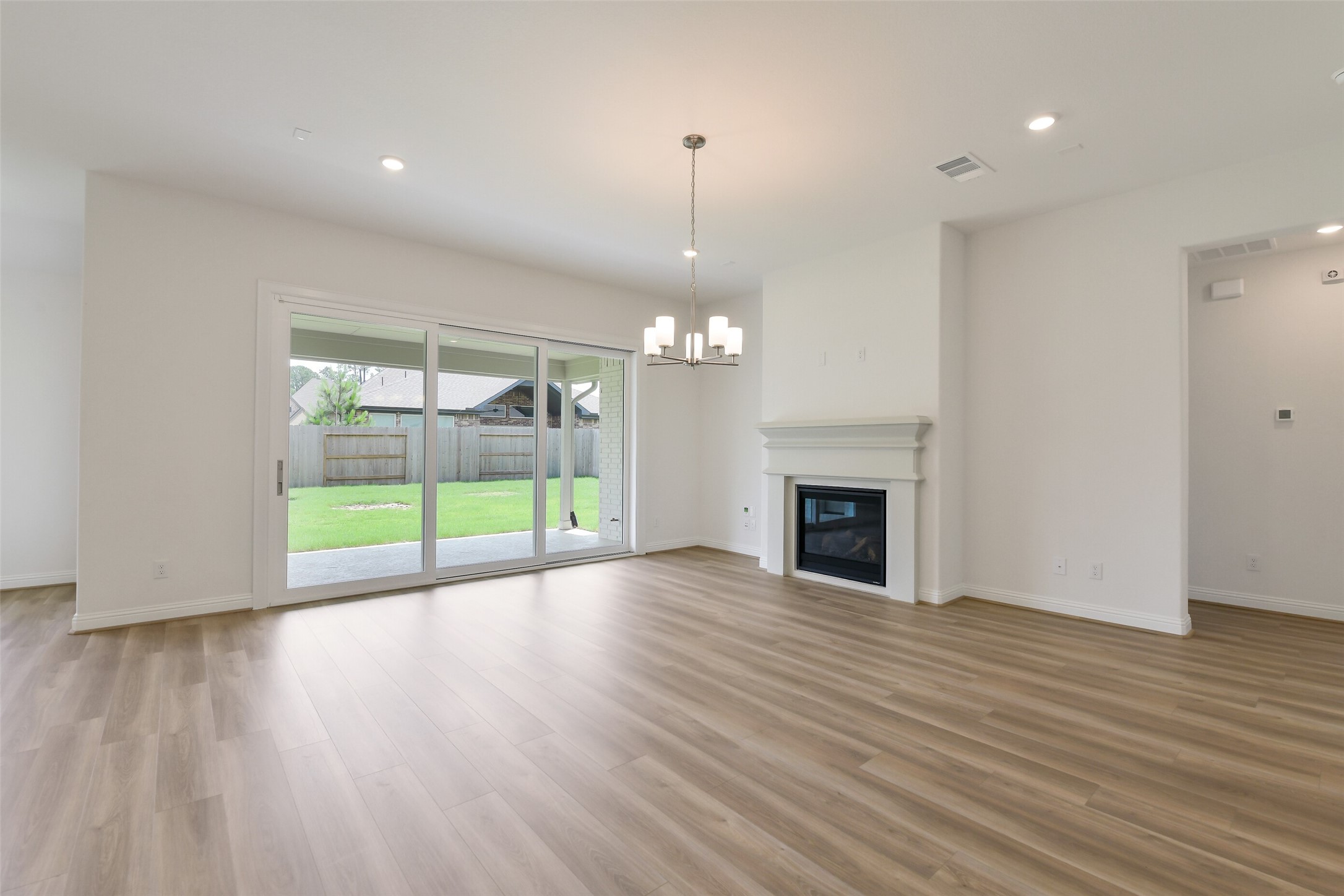 16119 Rustling Wds Road Conroe, TX 77302 - Photo 5 of 43 a view of an empty room with wooden floor and a fireplace