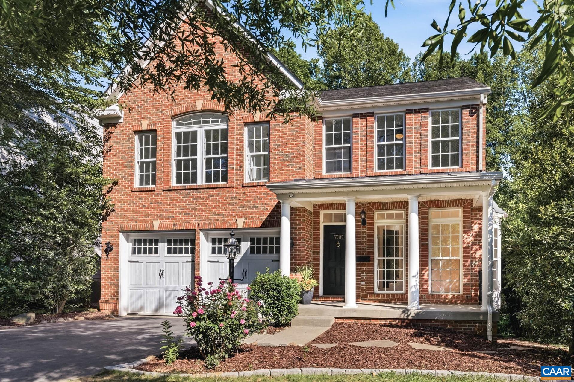 A stately brick exterior, one of two brick detached homes in the neighborhood, framed by mature landscaping.