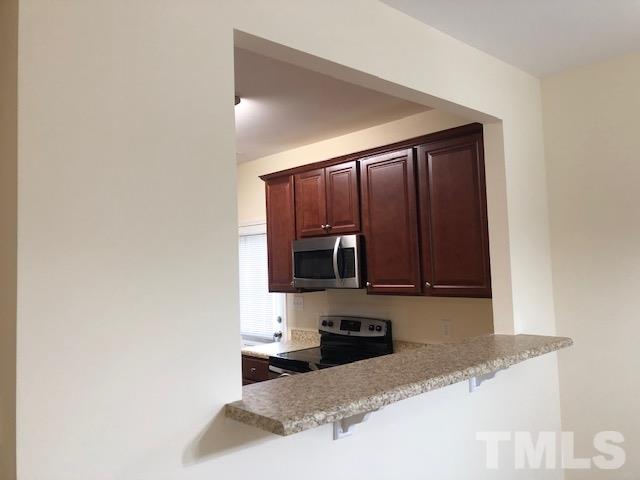 520 Branch Street Raleigh, NC 27601 - Photo 4 of 13 a kitchen with granite countertop a stove a microwave and sink