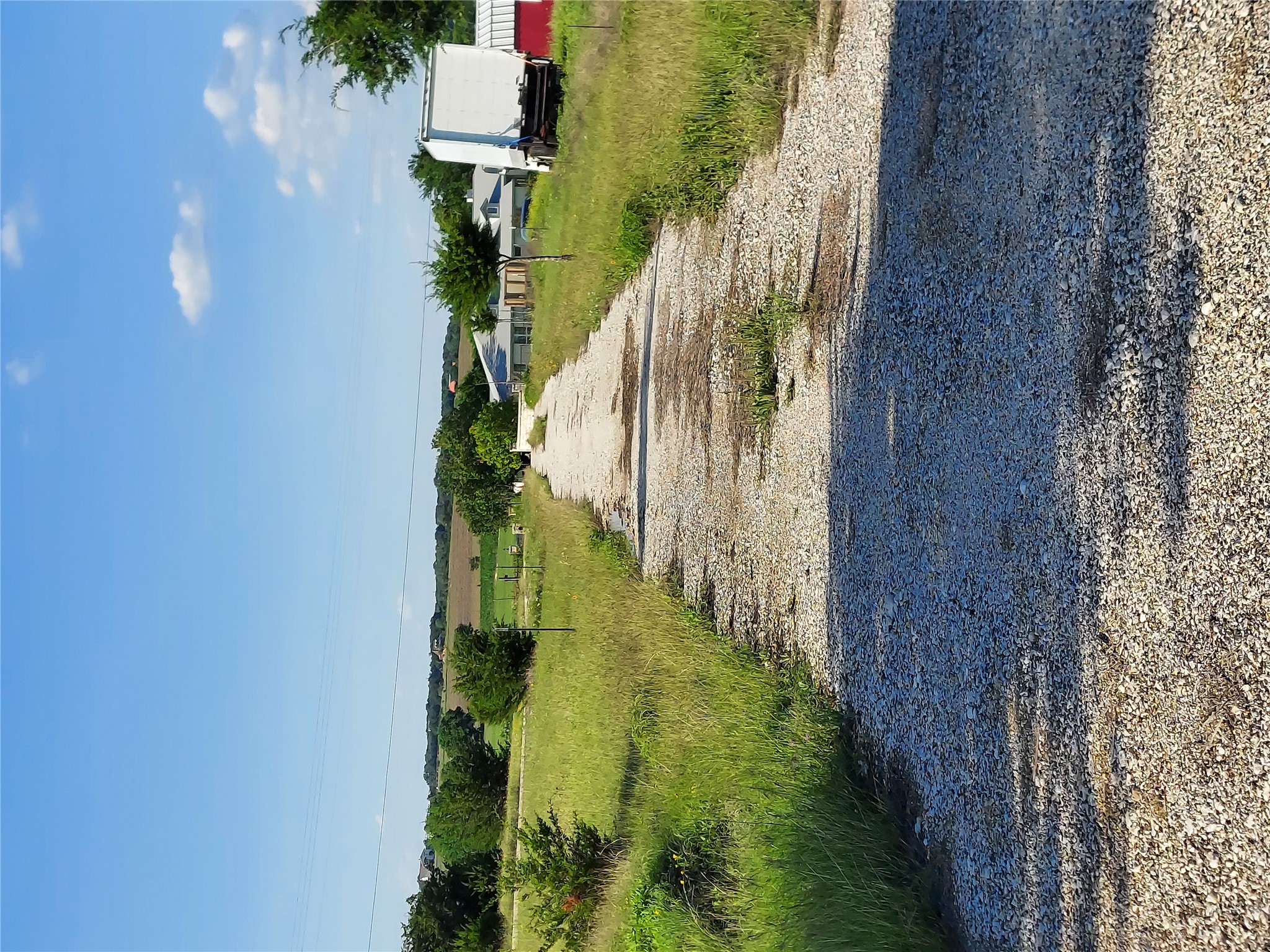 906 County Road 154 Georgetown, TX 78626 - Photo 8 of 11 Gravel driveway surrounded by expansive green space and distant mature trees