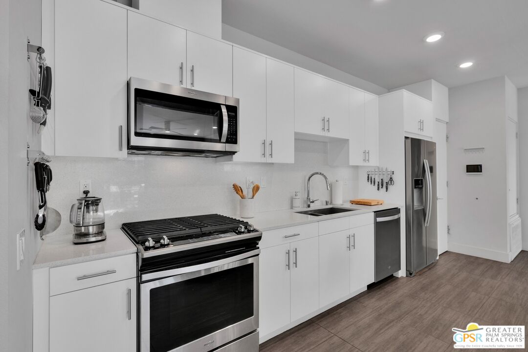138 The River Palm Springs, CA 92262 - Photo 16 of 47 a kitchen with stainless steel appliances a sink stove and microwave