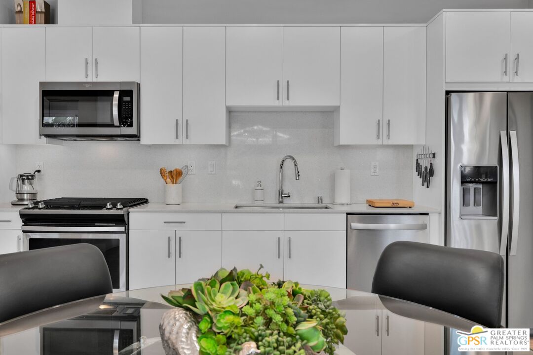 138 The River Palm Springs, CA 92262 - Photo 17 of 47 a kitchen with stainless steel appliances a stove a sink a microwave and cabinets