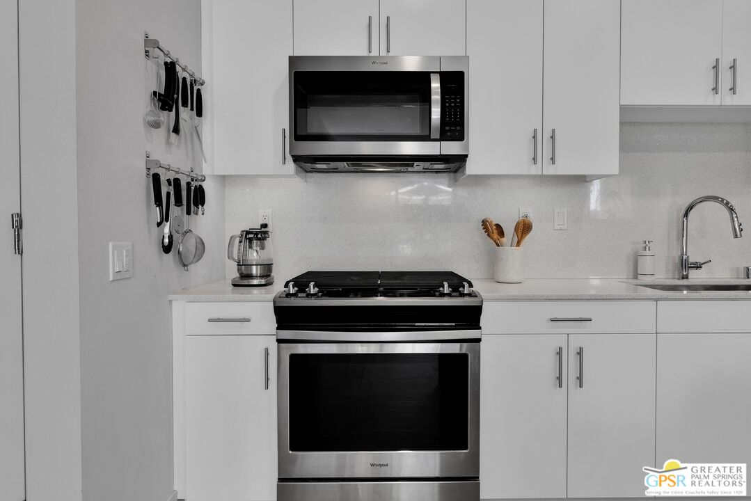 138 The River Palm Springs, CA 92262 - Photo 19 of 47 a kitchen with stainless steel appliances a stove and a microwave