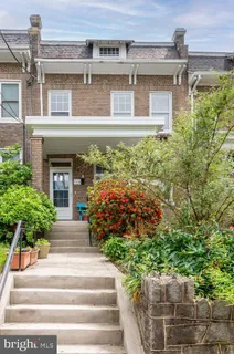 a front view of a house with plants and garden