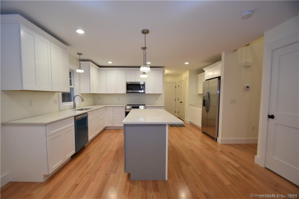 Mile Hill Road Tolland, CT 06084 - Photo 11 of 32 a open kitchen with wooden floor and stainless steel appliances
