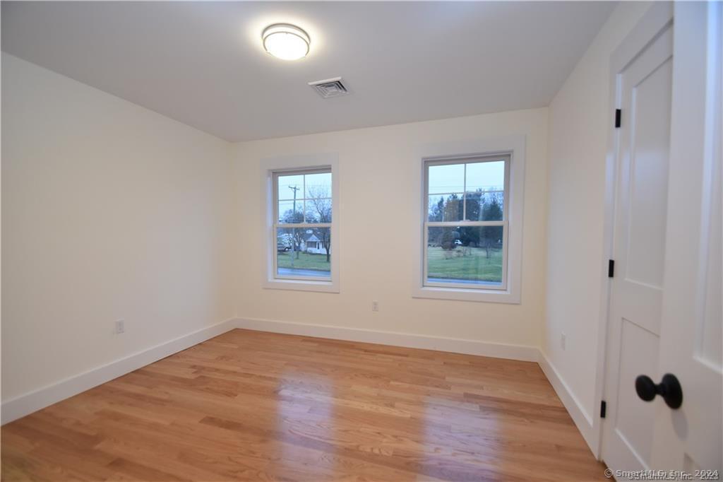 Mile Hill Road Tolland, CT 06084 - Photo 25 of 32 an empty room with wooden floor and windows