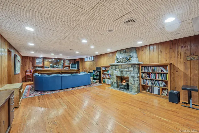 a large room with furniture a fireplace and a bookshelf