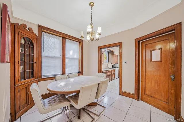 a dining room with furniture a chandelier and window