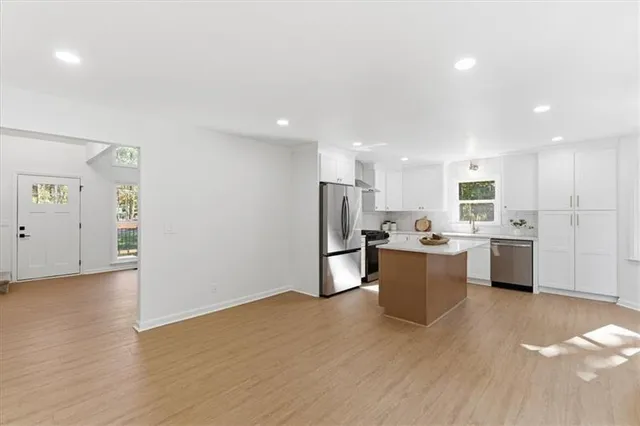 an empty room with windows and fan