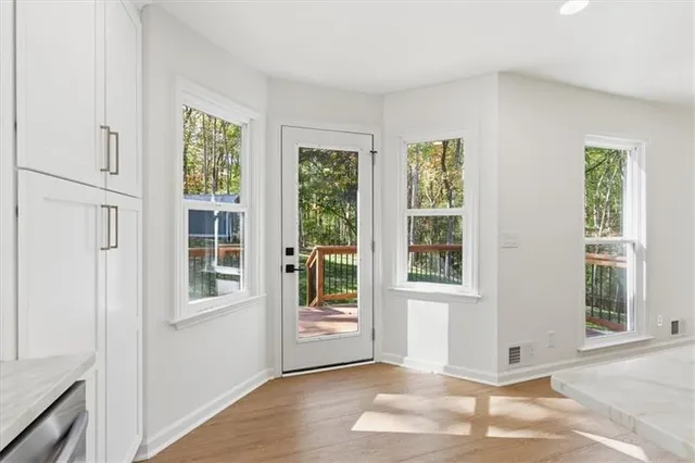 an empty room with windows and ceiling fan