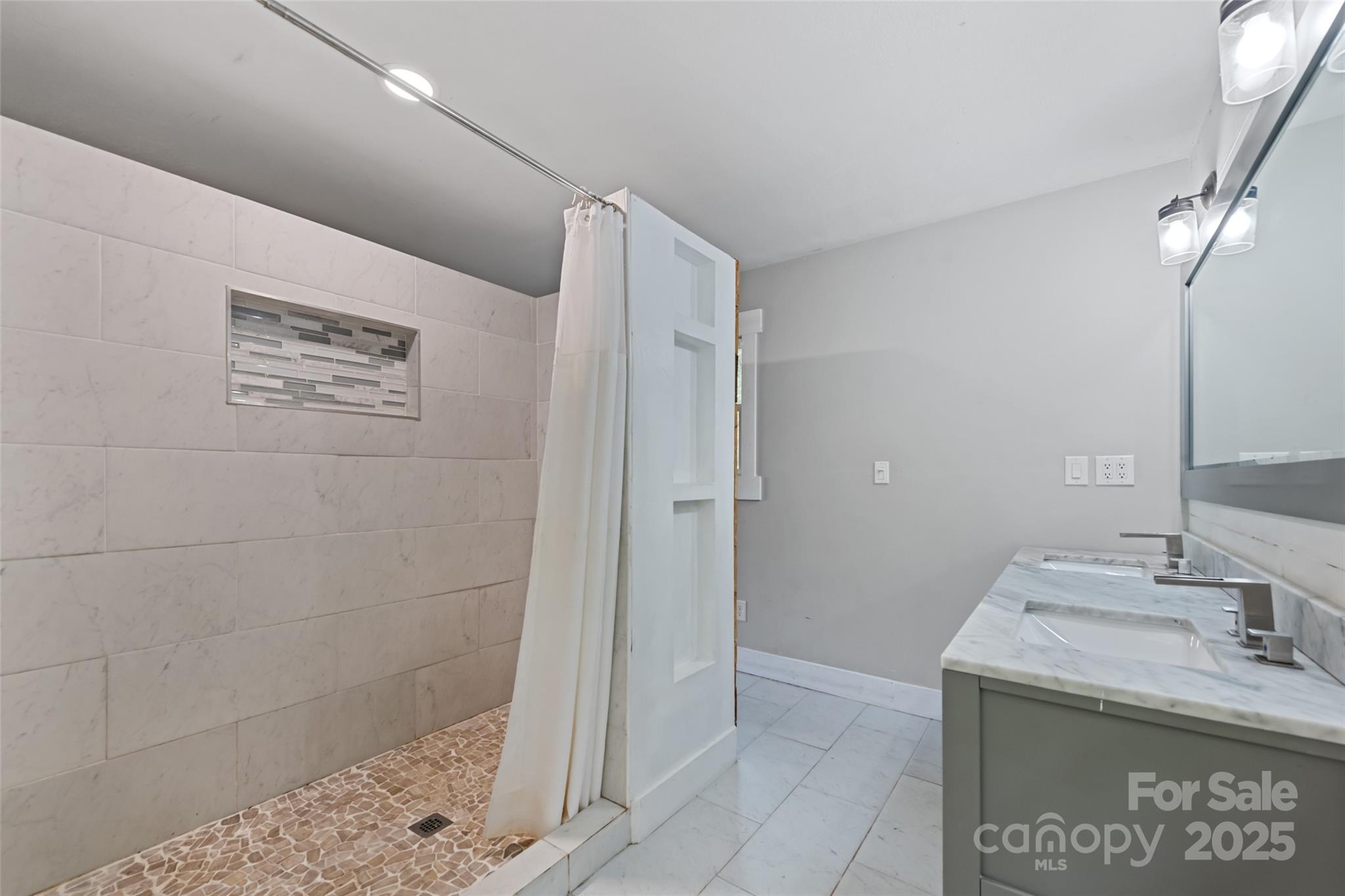 940 Haynes Cove Clyde, NC 28721 - Photo 26 of 48 a bathroom with a granite countertop sink a shower and a mirror