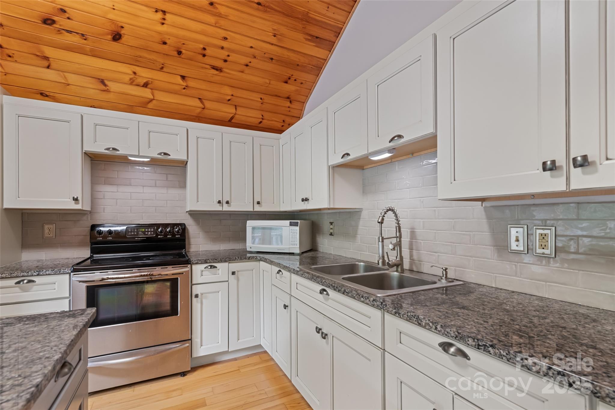 940 Haynes Cove Clyde, NC 28721 - Photo 43 of 48 a kitchen with granite countertop a stove sink and cabinets